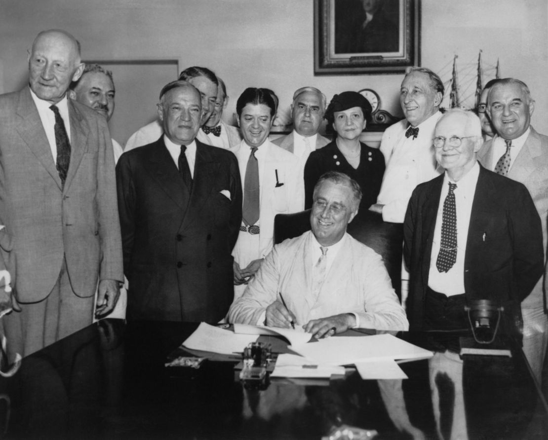 President Franklin D. Roosevelt (seated) signs the Social Security Act on August 14, 1935.