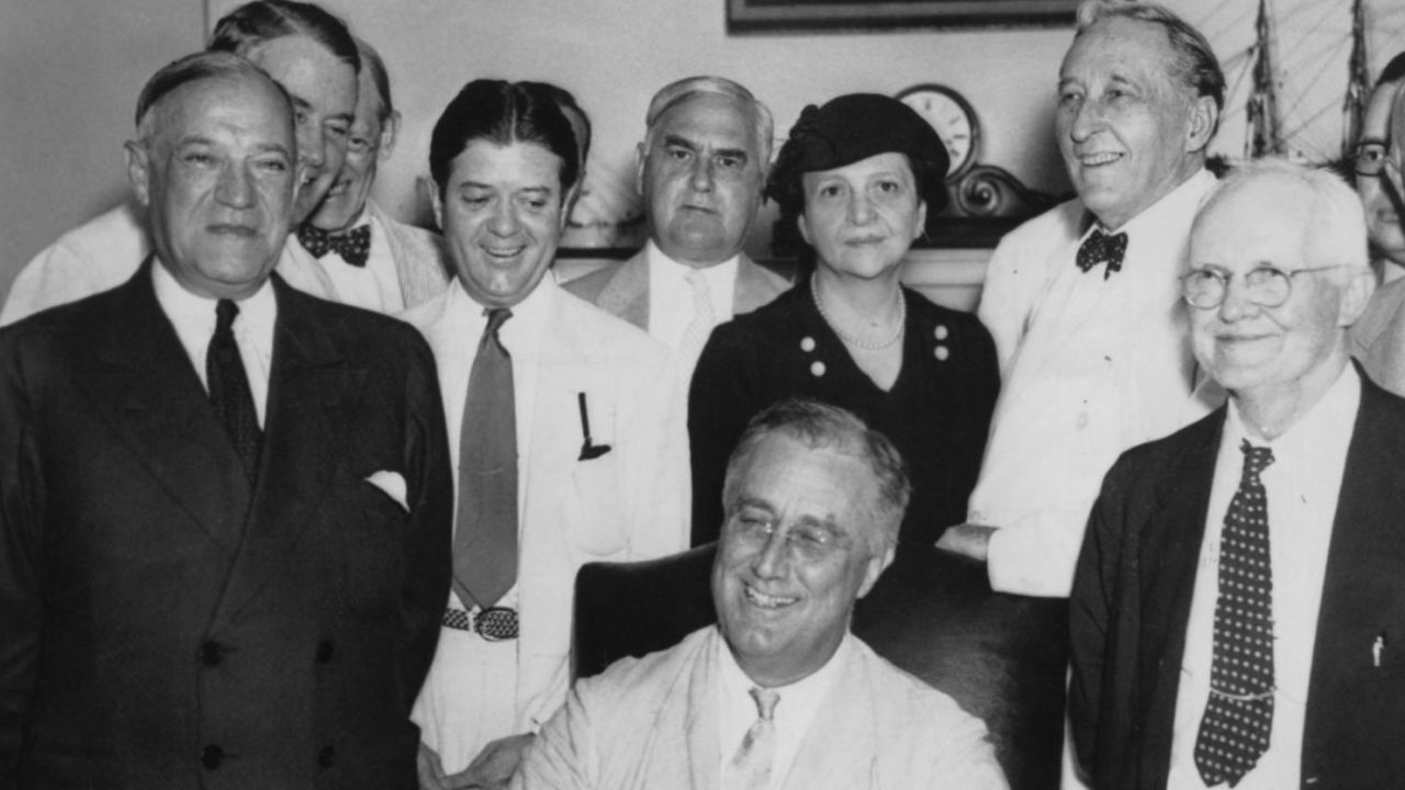 Frances Perkins stands behind President Franklin D. Roosevelt as he signs the Social Security Act into law in August 1935. (FPG/Archive Photos/Getty Images)
