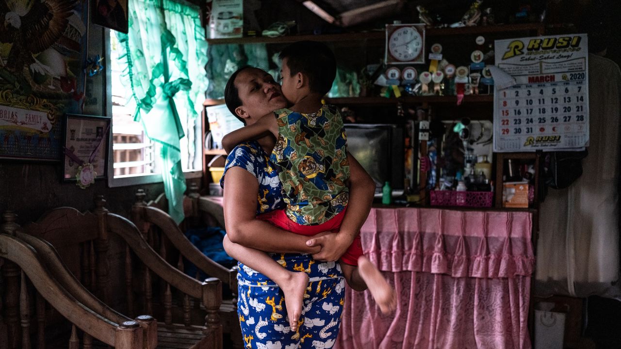 April Abrias hugs her son, Yohan, inside their home after she has disinfected and changed her clothes.