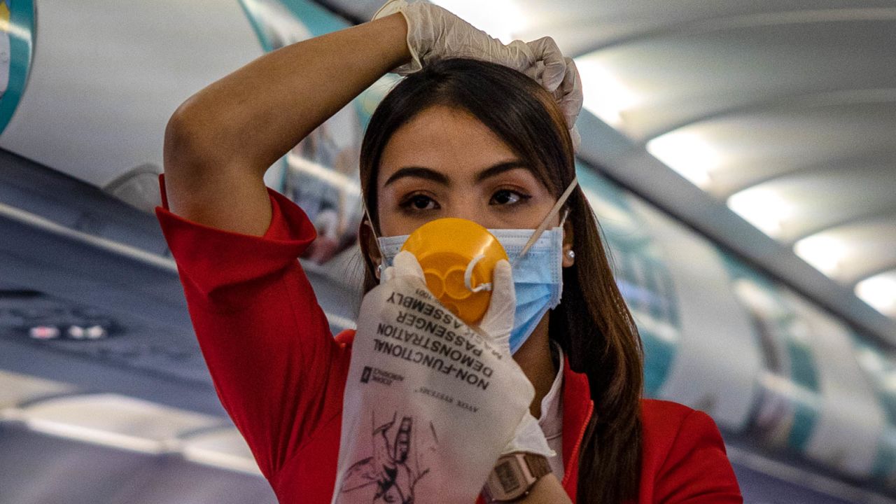 INCHEON, SOUTH KOREA - MARCH 10: A flight attendant is seen wearing a facemask and gloves as protection from COVID-19 while demonstrating safety procedures aboard an AirAsia flight bound for Manila, Philippines, at Incheon International Airport on March 10, 2020 in Incheon, South Korea. According to the Korea Centers for Disease Control and Prevention, 131 new cases have been reported, with the death toll rising to 54. The total number of infections in the nation tallies at 7,513. (Photo by Ezra Acayan/Getty Images)