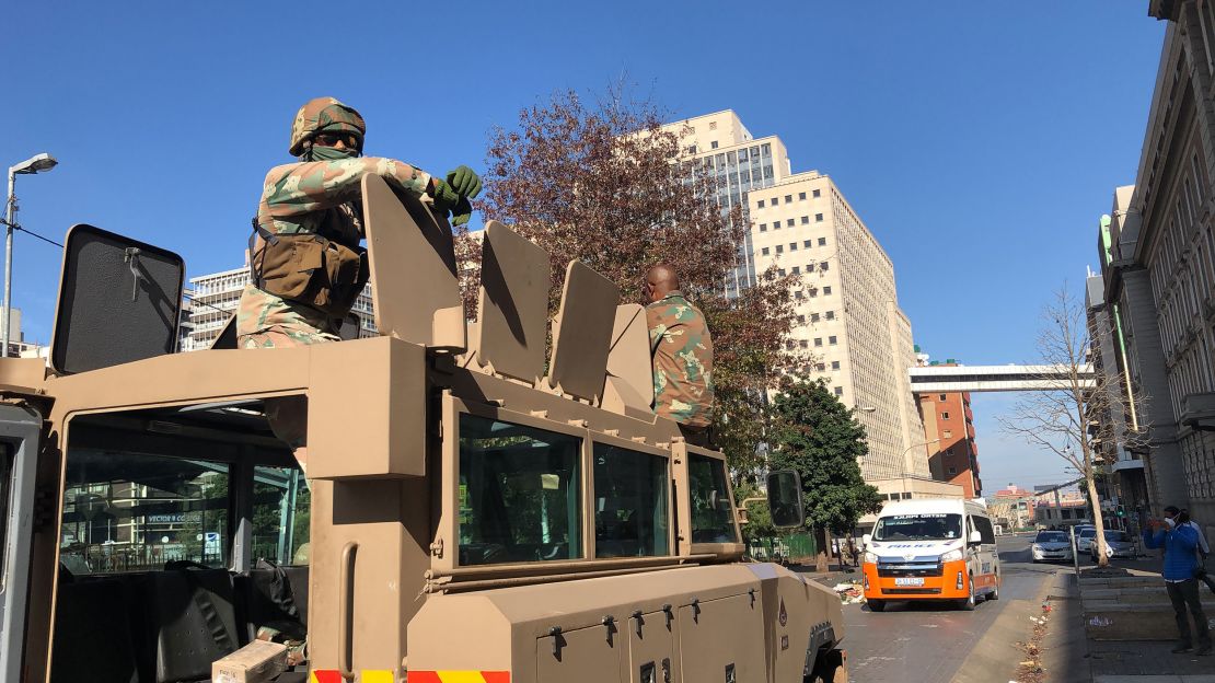 Two South African soldiers sit on top of their armored personnel carrier in Johannesburg city center.