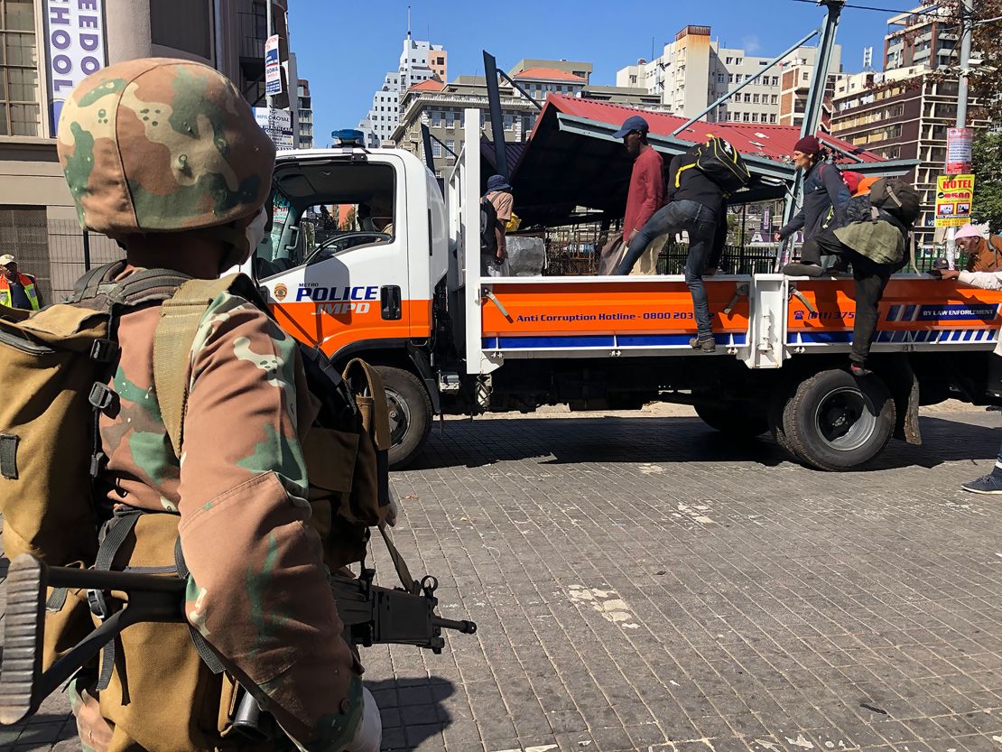 Homeless South Africans in Johannesburg are loaded on the back of a police truck where they were told they would be taken to a shelter to stay during the  lockdown.