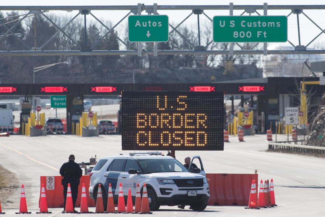 US Customs officers stand beside a sign at the US-Canada border in Lansdowne, Ontario, on March 22, 2020. 