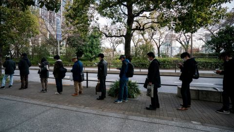 Commuters wait in line at a bus stop on March 26, 2020 in Tokyo, Japan. 