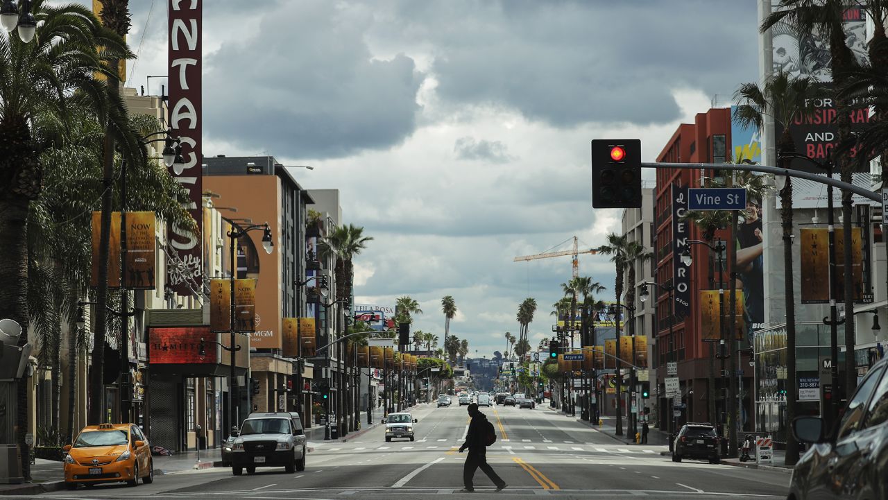 LOS ANGELES, CALIFORNIA  - MARCH 25: A man crosses the unusually quiet Hollywood Boulevard near the shuttered Pantages Theatre as the coronavirus pandemic continues on March 25, 2020 in Los Angeles, California. California Governor Gavin Newsom issued a 'stay at home' order for California's 40 million residents, with exceptions for essential activities, in order to slow the spread of COVID-19.  (Photo by Mario Tama/Getty Images)