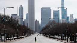 An elderly lady walks across the usually busy Columbus Drive that splits Chicago's Grant Park in half, on the first work day 