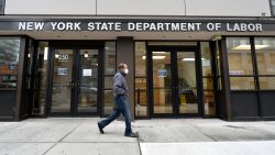 Surge in US unemployment claims cuases Governemnt servers to crash. A man wearing a protective mask walks past the New York State Department of Labor offices in the New York City borough of Brooklyn, NY, March 25, 2020. Anthony Behar/Sipa/Reuters