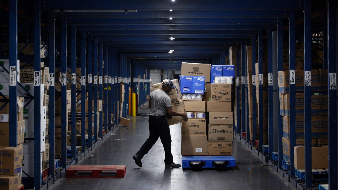A worker loads boxes onto a pallet at a Kroger Co. grocery distribution center in Louisville, Kentucky, on March 20, 2020.