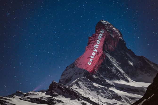 The hashtag "stayhome" is projected onto the Matterhorn mountain that straddles Switzerland and Italy on April 1, 2020. The mountain was illuminated by Swiss artist Gerry Hofstetter, who was transforming buildings, monuments and landscapes all over the world to raise awareness during the pandemic. 