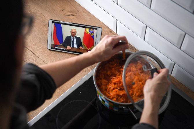 A woman in Moscow cooks while watching Russian President Vladimir Putin address the nation over the coronavirus pandemic.