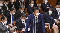 Japanese Prime MInister Shinzo Abe, wearing a face mask to help protect against the spread of the new coronavirus, answers questions as other masked lawmakers listen at the parliament's upper house in Tokyo Wednesday, April 1, 2020. 