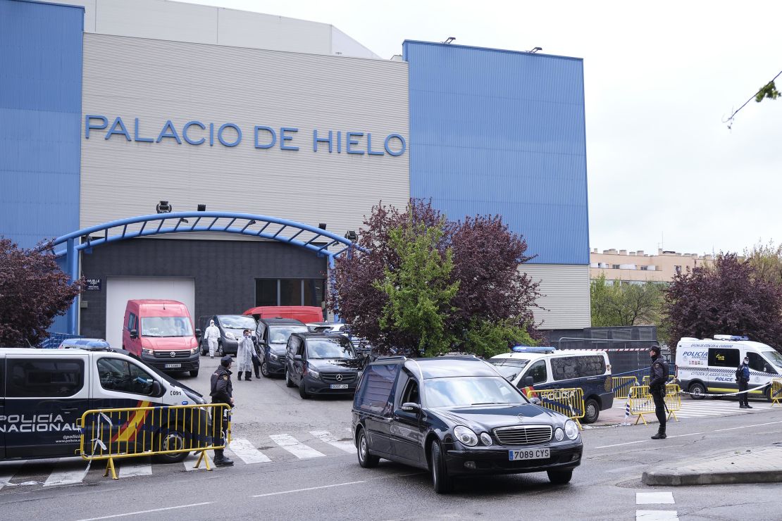 Funeral cars and vans wait outside an ice rink, temporarily converted into a morgue to house hundreds of bodies, in Madrid.