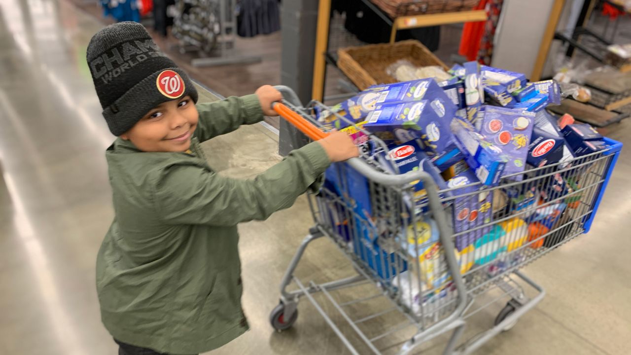 Cavanaugh Bell, 7, shops for items to make care packages for the elderly.