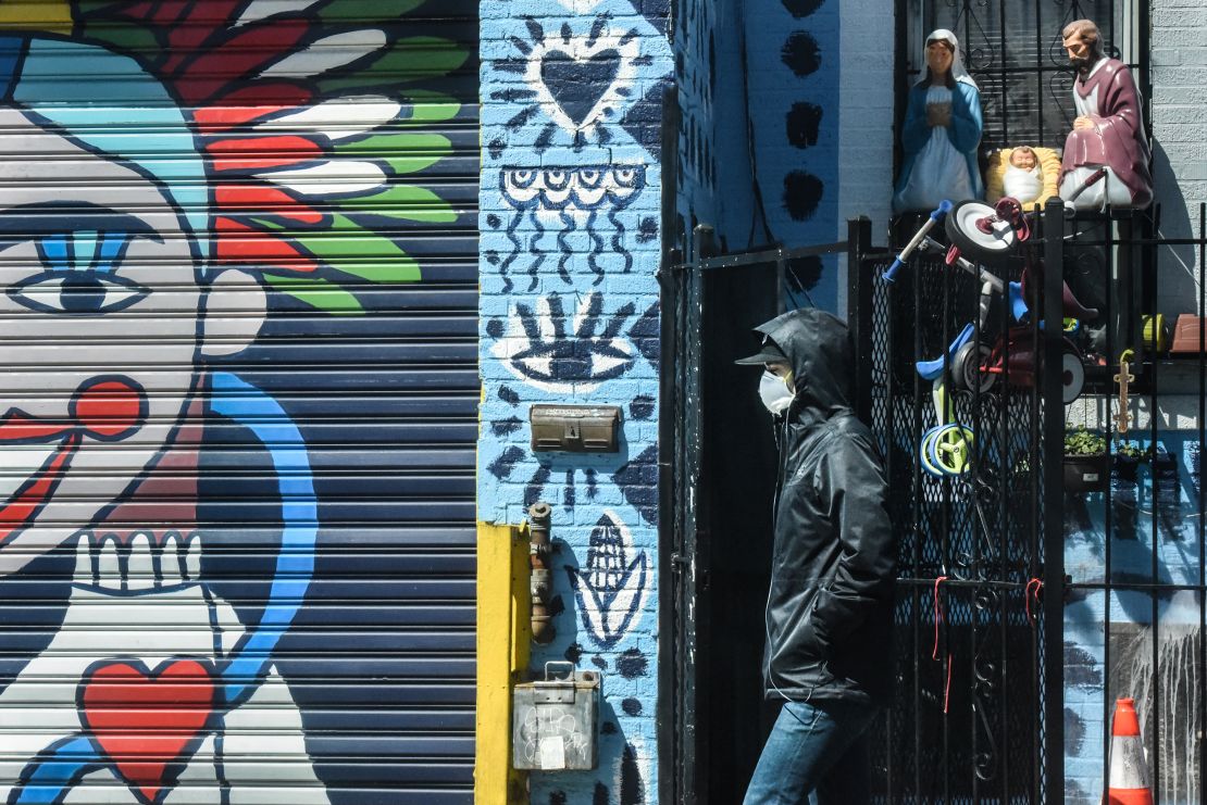 A person wears a protective masks while walking past street art in the Bushwick neighborhood of Brooklyn on April 2, 2020 in New York City.