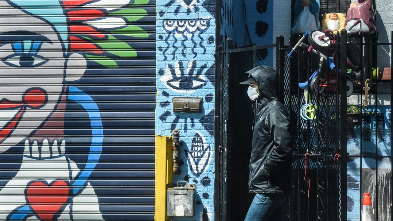 A person wears a protective masks while walking past street art in the Bushwick neighborhood of Brooklyn on April 2, 2020 in New York City.