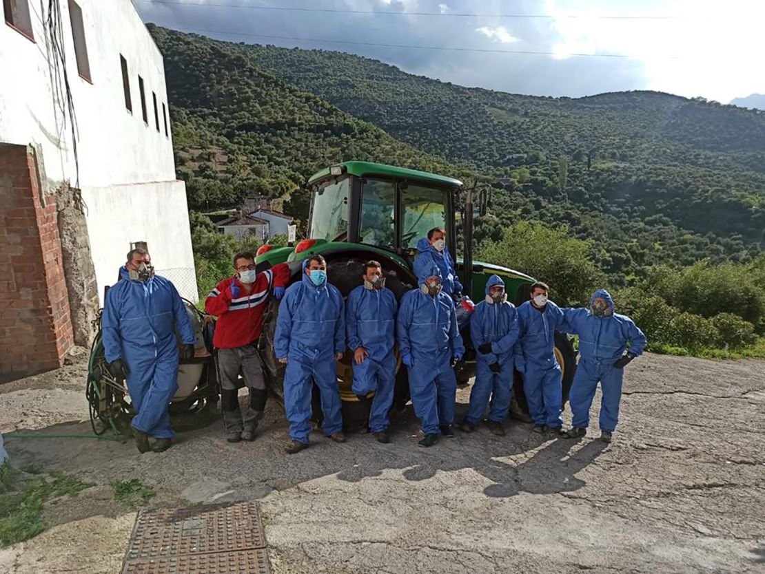 A group of volunteers and town workers clean and disinfect the streets.