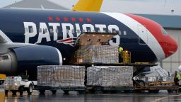 Palettes of N95 respirator masks are off-loaded from the New England Patriots football team's customized Boeing 767 jet on the tarmac, Thursday, April 2, 2020, at Logan Airport in Boston, after returning from China. The Kraft family deployed the Patriots team plane to China to fetch more than one million masks for use by front-line health care workers to prevent the spread of the coronavirus.