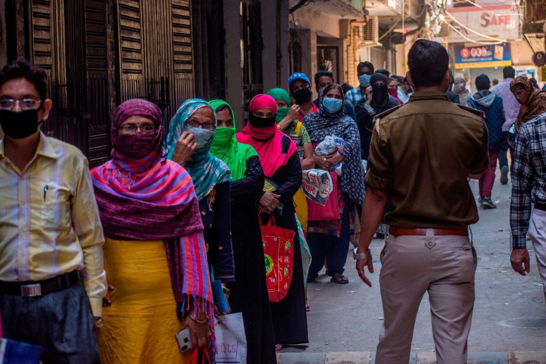 Indians wait to receive rations during the nationwide lockdown on April 2, 2020 in New Delhi.