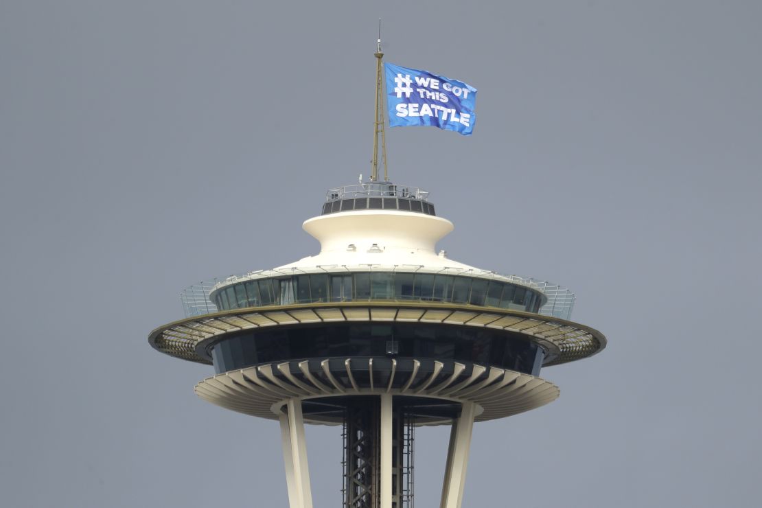 Seattle Mayor Jenny Durkan raises a flag on the roof of the Space Needle reading, "#We Got This Seattle," saying it was intended as a symbol of encouragement and solidarity. 