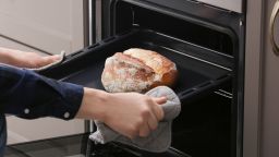 person baking bread oven STOCK