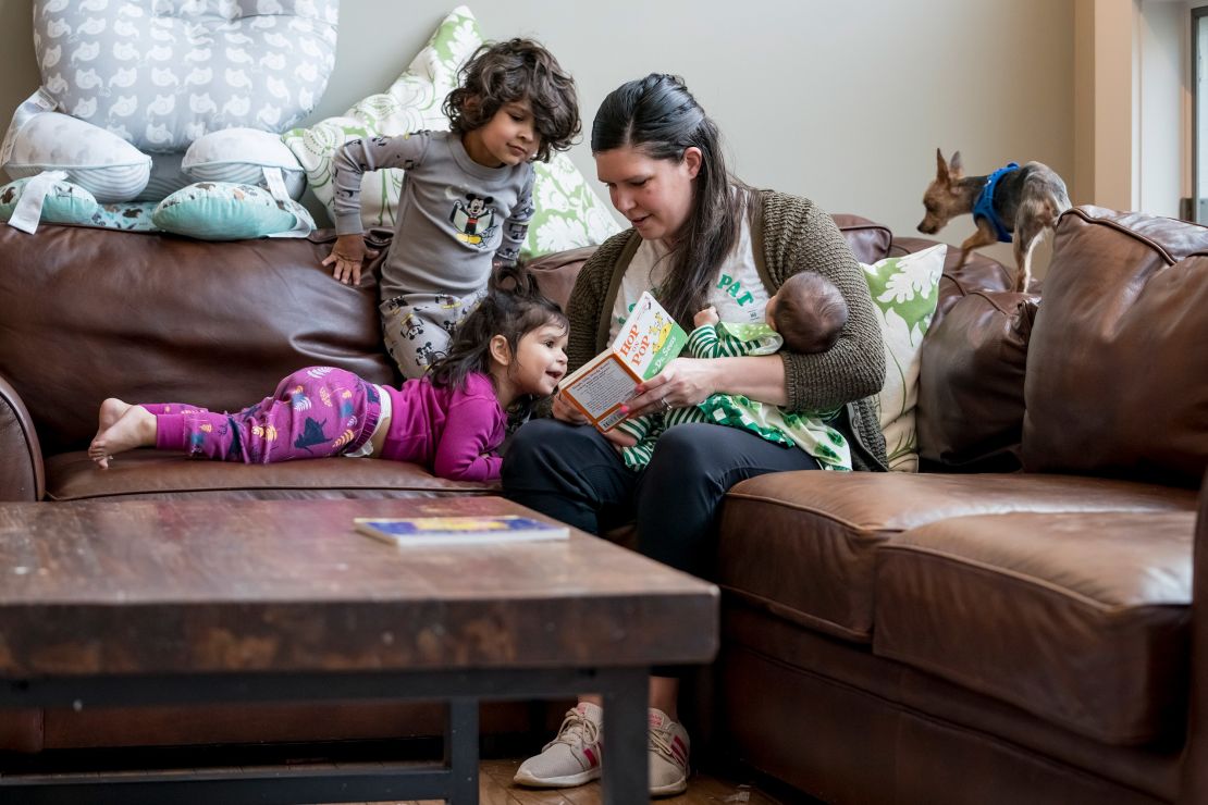 Katie Patel holds her 3-month old daughter, Lucy, as she reads to her son Parker, 3, and daughter, Isla, 1, before bedtime at their home in Creve Coeur, Missouri, on March 17, 2020. (Photo by Whitney Curtis for The Washington Post/Getty Images)