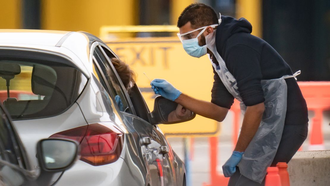 Medical staff work at a National Health Service drive-through coronavirus testing facility in an IKEA car park in Wembley, London.