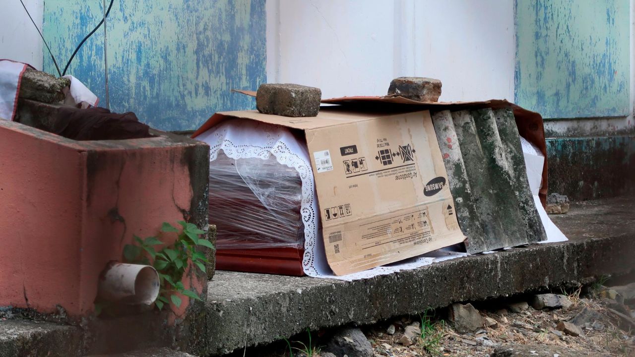 A coffin containing the body of a person who is supposed to have died from Covid-19 lays wrapped in plastic and covered with cardboard, outside a block of family apartments in Guayaquil on April 2.