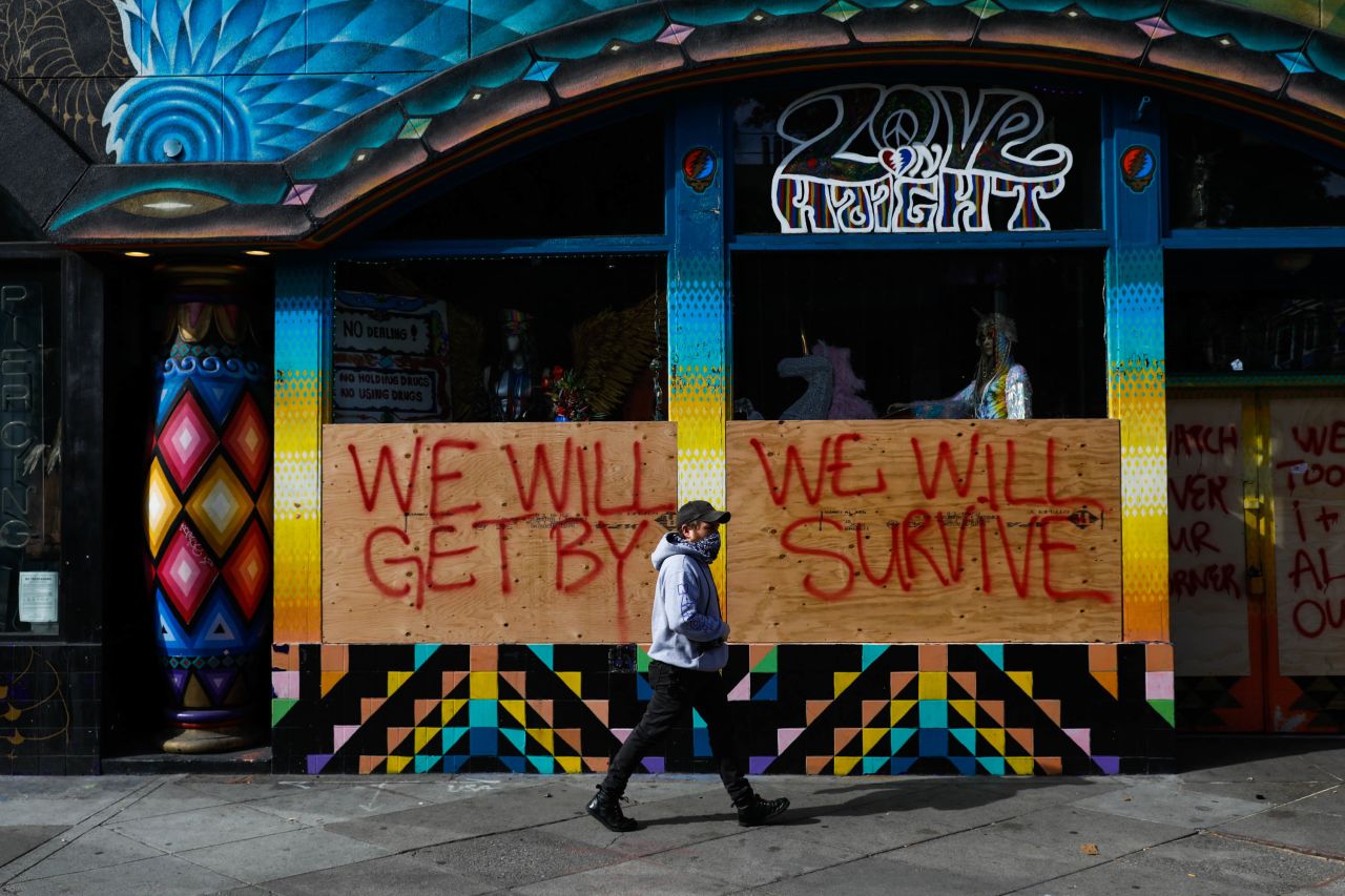 A man passes by a boarded-up store in San Francisco on March 17.