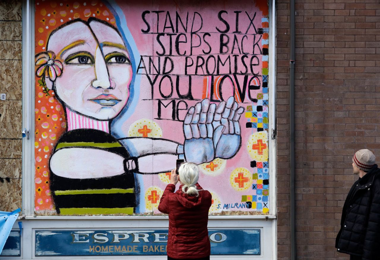 A pedestrian takes a photo of artwork in Seattle on March 23.