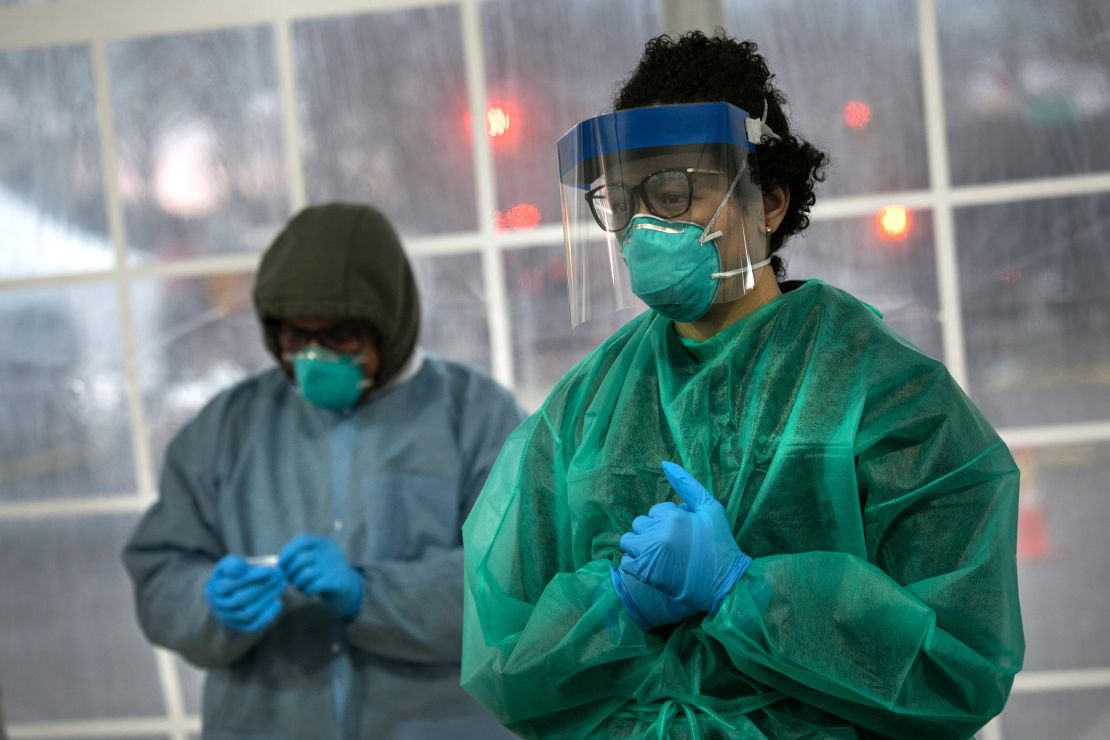 A doctor from SOMOS Community Care prepares to test a patient at a drive-thru testing center for coronavirus.