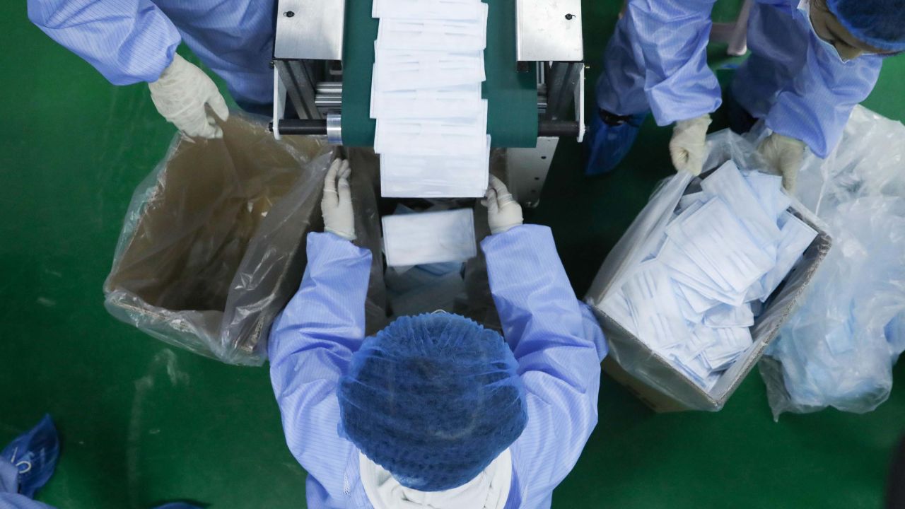 Workers pack newly produced masks at a plant in Beijing, China last month.