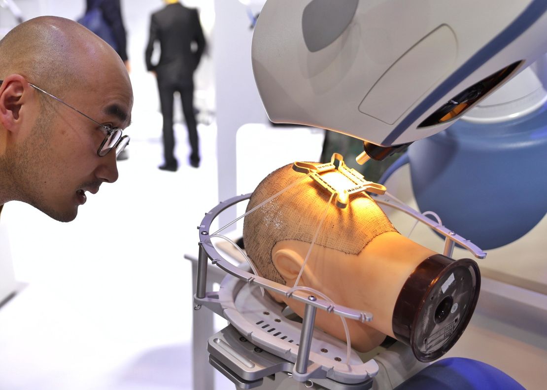A man looks at a robotic hair transplant machine at the China International Import Expo in Shanghai in 2019.