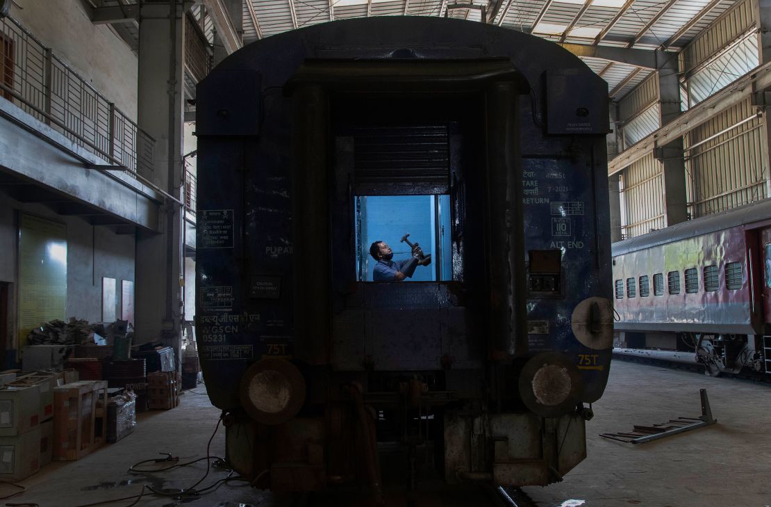 An Indian railway employee works to convert a train coach into an isolation ward for the fight against the new coronavirus in Gauhati, India, Sunday, March 29, 2020.