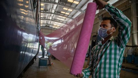 Indian railway employees fix mosquito nets as they work to convert a train coach into an isolation ward for the fight against the new coronavirus in Gauhati, India, Sunday, March 29, 2020.  