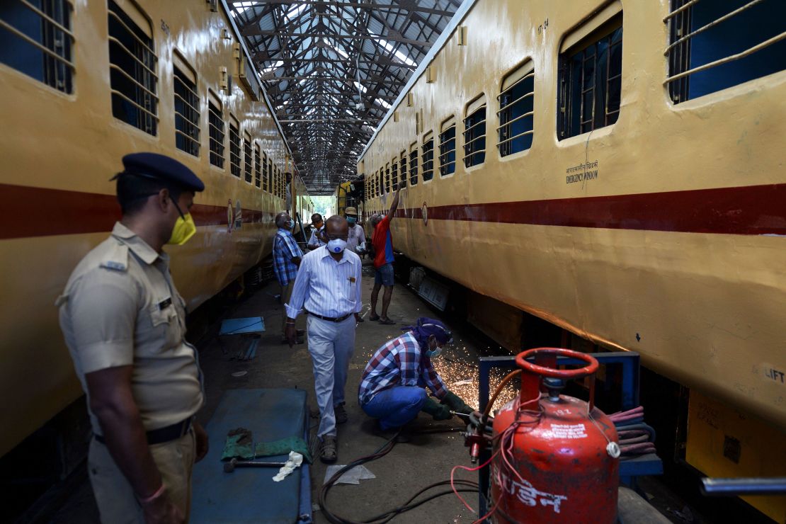 Workers wearing facemasks carry on works on train coaches that will be used as temporary isolation wards in preparation for Covid-19 coronavirus patients, at a coach factory workshop in Chennai on March 30, 2020.