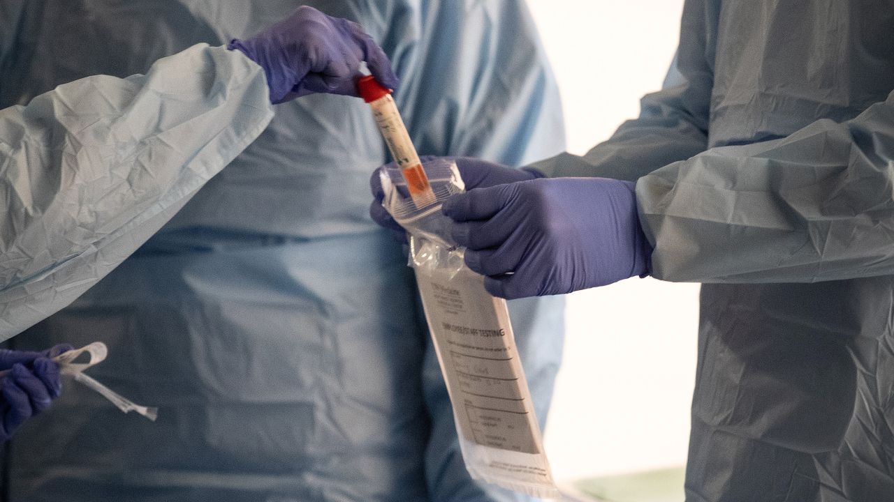 SEATTLE, WASHINGTON - MARCH 13: Nurses wearing protective clothing handle a vial containing a potentially infected coronavirus swab at a drive-by testing center at the University of Washington Medical campus on March 13, 2020 in Seattle, Washington. UW Medical staff feeling potential symptoms of COVID-19 were asked to pass through a drive-through screening center for testing. (Photo by John Moore/Getty Images)