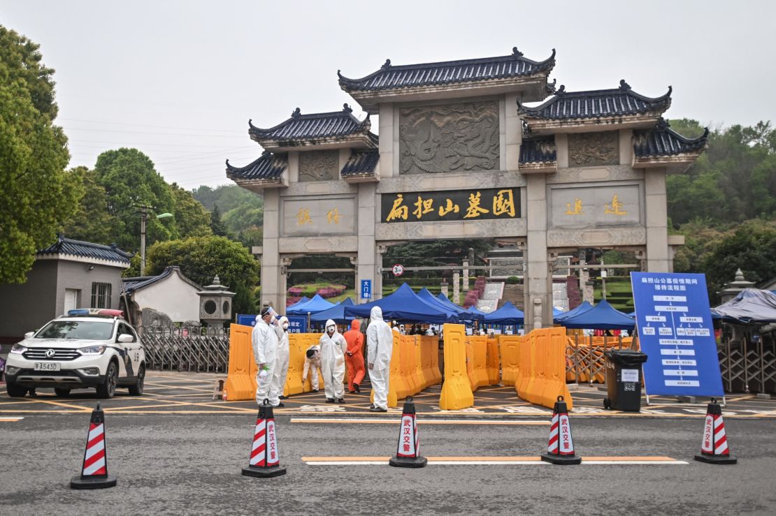 People wearing hazmat suits standing guard at the entrance to the Biandanshan cemetery in Wuhan on March 31.