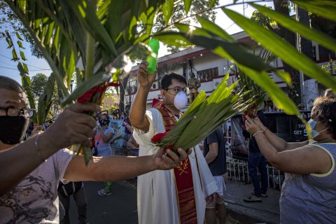 A Catholic priest sprinkles holy water on devotees during Palm Sunday celebrations in Quezon City, Philippines, on April 5, 2020.