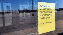 A closed sign is shown with an empty parking lot in Detroit, Thursday, April 2, 2020.