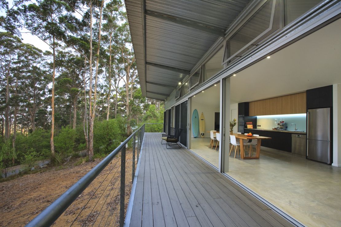 Designed by Ian Weir and Kylie Feher, Karri House in Denmark, Western Australia, prioritizes design over land clearing. Bushfire shutters are used on a daily basis to block out light and insects. "My aim with my work is to build houses that will give extreme, very high levels of confidence so that people can leave early and the house will sustain itself without their help," architect Ian Weir said.