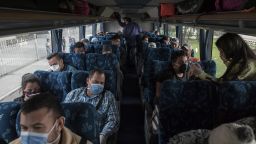 Venezuelan migrants wear protective masks while sitting on a bus that will return them back to Venezuela, in Bogota, Colombia, on Sunday, April 5, 2020. Venezuelan families made destitute by Colombia's coronavirus lockdown are traveling a thousand miles or more across the Andes to get back home. Photographer: Ivan Valencia/Bloomberg via Getty Images
