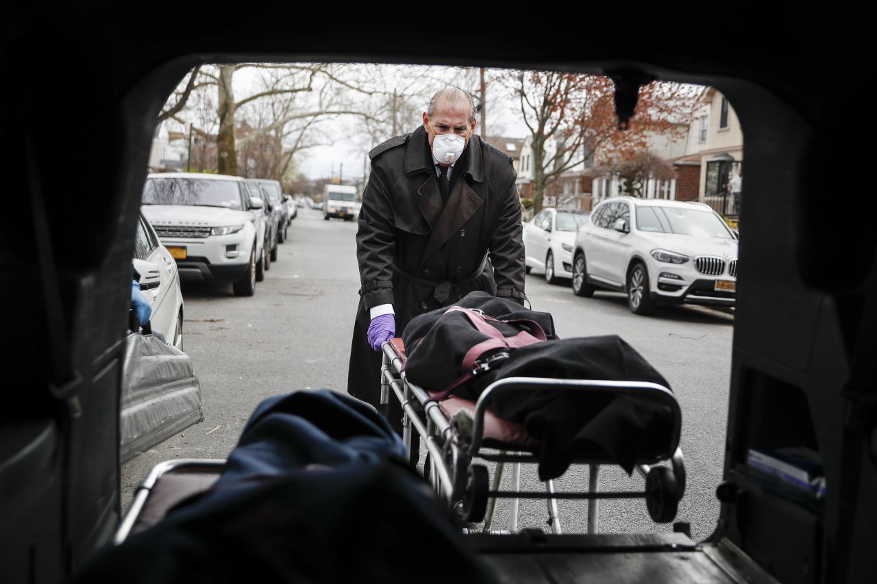 Funeral director Tom Cheeseman loads a body into his van in Brooklyn, New York, after making a house call on Friday, April 3. The Associated Press spent a day on the road with Cheeseman, who is overwhelmed by demand due to the coronavirus outbreak.