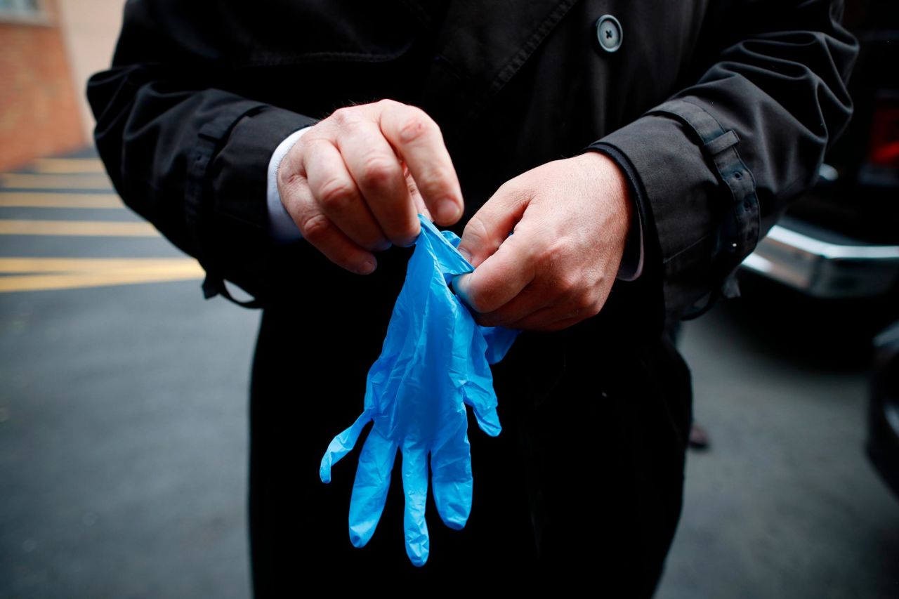 Cheeseman puts on protective gloves as he delivers a body to a funeral home on Friday, April 3. "We took a sworn oath to protect the dead, this is what we do," Cheeseman told The Associated Press. "We're the last responders. Our job is just as important as the first responders."