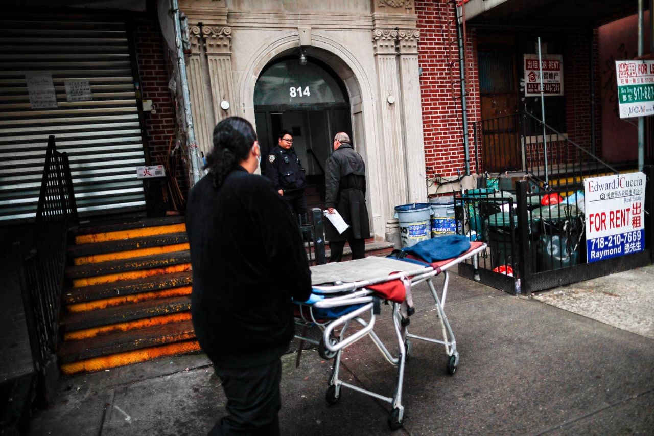 Cheeseman, center, and a colleague make a house call to collect a body on Friday, April 3.