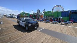 Police patrol an empty Santa Monica Pier in Santa Monica, California on March 23, 2020, as people are encouraged to stay at home to halt the spread of the novel coronavirus, COVID-19. (Photo by Robyn Beck / AFP) (Photo by ROBYN BECK/AFP via Getty Images)