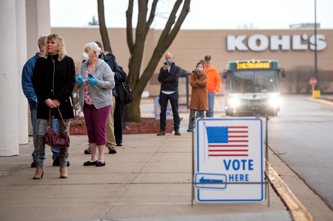 Voters line up outside of a permanently closed Sears before polls open at the Janesville Mall on Tuesday, April 7, 2020, in Janesville, Wis. 