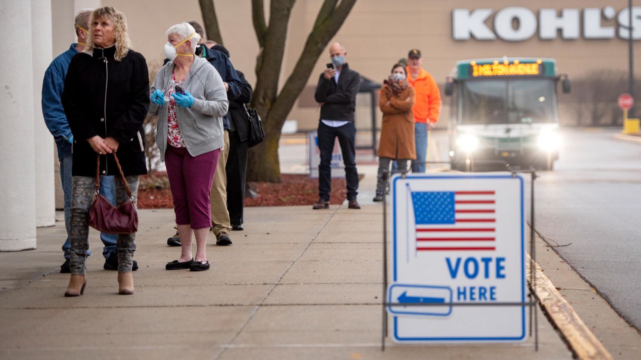 Voters line up outside of a permanently closed Sears before polls open at the Janesville Mall on Tuesday, April 7, 2020, in Janesville, Wis. 