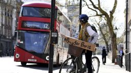 A woman shows a sign on her bicycle as British Prime Minister Boris Johnson is in intensive care fighting the coronavirus in London, Tuesday, April 7, 2020. Johnson was admitted to St Thomas' hospital in central London on Sunday after his coronavirus symptoms persisted for 10 days. Having been in hospital for tests and observation, his doctors advised that he be admitted to intensive care on Monday evening. The new coronavirus causes mild or moderate symptoms for most people, but for some, especially older adults and people with existing health problems, it can cause more severe illness or death.(AP Photo/Alberto Pezzali)