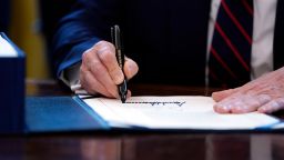 President Donald Trump signs the coronavirus stimulus relief package, at the White House, Friday, March 27, 2020, in Washington. 