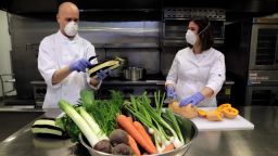 OAKLAND, CA - APRIL 2: Caterer Aliza Grayevsky Somekh, right, and her husband Nadav Somekh prepare vegetables for takeaway Seder plates in the kitchen at Temple Beth Abraham in Oakland, Calif., on Thursday, April 2, 2020. Her catering business, Bishulim SF usually prepares contemporary Israeli cuisine, but for Passover, she's making take-home dinners for people to observe the holiday in their homes while still keeping some of the traditions intact. (Carlos Avila Gonzalez/The San Francisco Chronicle via Getty Images)